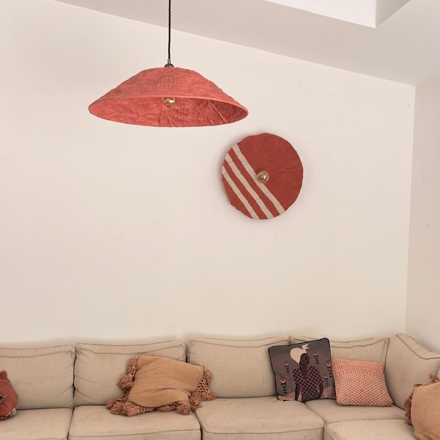 Suspension OMBRELLE orange terracotta en plastique recyclé au-dessus d’une table en bois, pour un éclairage durable de son salon