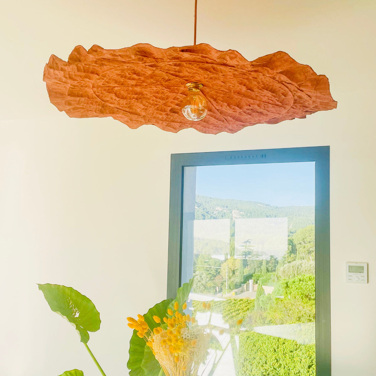 Abat-jour suspension PÉTALE terracotta écoresponsable installé au-dessus d’une table